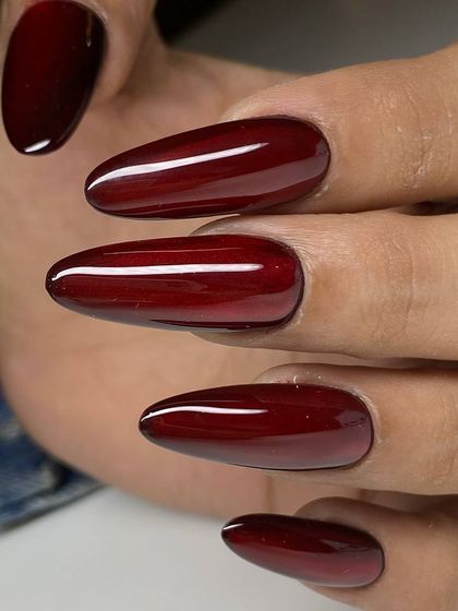 A deep, vampy red with a cat-eye effect on long, almond-shaped nails. The magnetic polish creates a stunning line of light that moves with you.