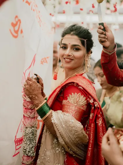 The bride's joyful smile as she participates in the wedding rituals. Her makeup is natural and radiant.
