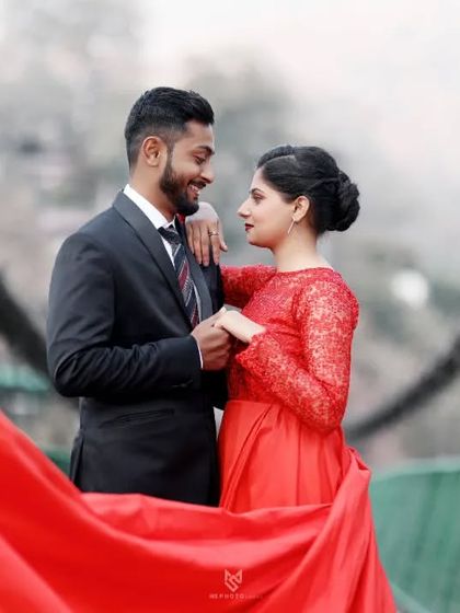 A close-up of the couple on the bridge, sharing a loving look. The red gown adds a vibrant pop of color to this romantic portrait.