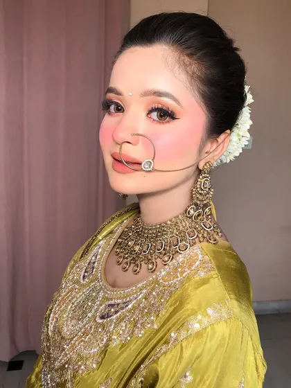 A close-up of her face, the nath and bindi completing the traditional Pahadi look.