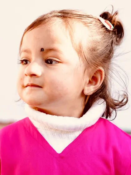 A sweet and innocent portrait of a young child. Capturing the natural curiosity of kids is always a joy, and this close-up shot in soft light makes for a beautiful memory.
