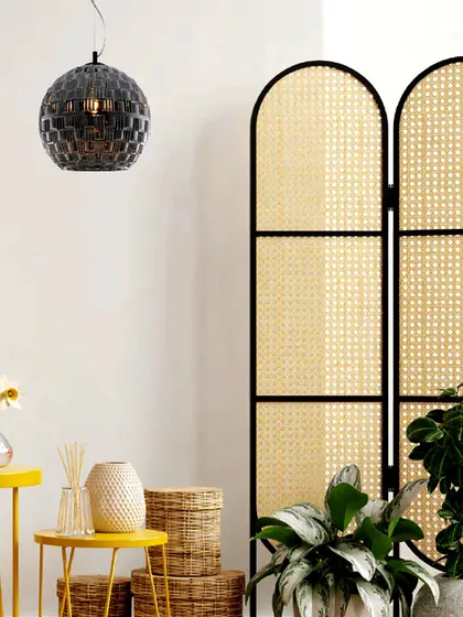 A spherical pendant with a patterned black glass finish adds a touch of graphic intrigue. This fixture shines brighter by casting unique shadows, making it a piece of functional art.