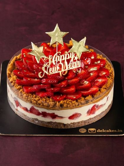 Our Strawberry Biscoff Cheesecake, all dressed up for New Year's. The 'Happy New Year' topper and gold stars make it extra festive.