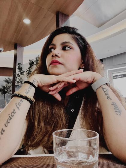 A thoughtful portrait showing my tattoos, including 'Be a voice for the voiceless'. This is a powerful visual representation of my personal mission and activist streak.