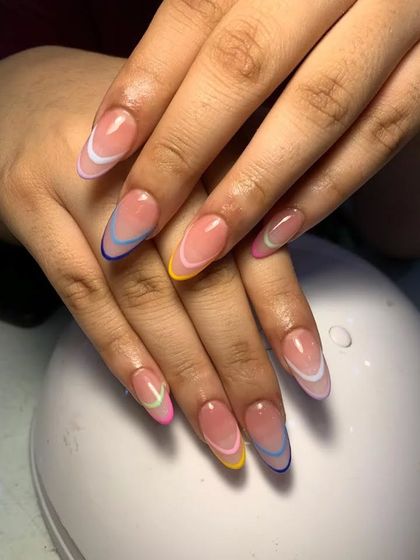 A playful rainbow French manicure, with each almond-shaped nail featuring a different colored tip.
