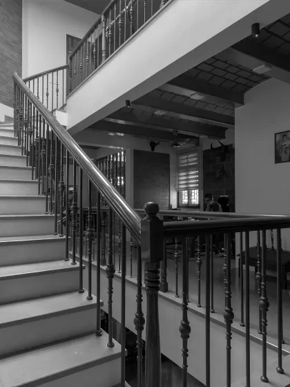 A low-angle view of the staircase, emphasizing its structural form and the different levels it connects within the open-plan home.