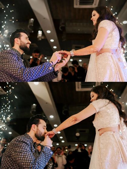 The groom gets down on one knee to offer the ring, a classic and emotional moment captured with sparklers in the background.