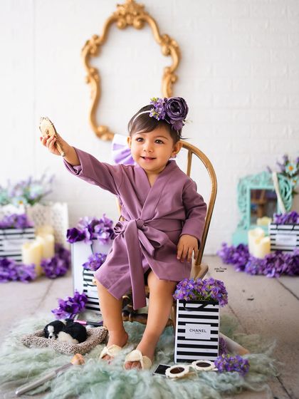 Getting ready for her close-up! This little one is admiring herself in the mirror during her fun, purple-themed spa day photoshoot.