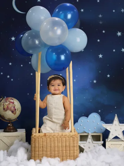 Up, up, and away! This sitter session featured a dreamy hot air balloon theme, complete with a starry night backdrop and fluffy clouds, creating a magical setting for this little explorer.