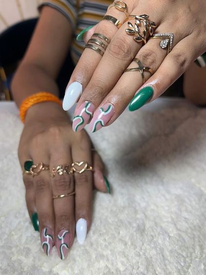 A cool green and white abstract design on stiletto nails. This shows how to use negative space to create a modern and airy look.