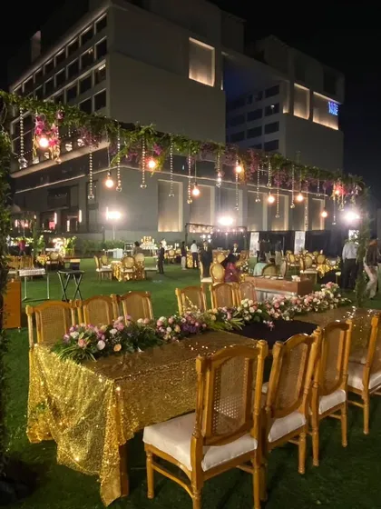 The outdoor seating for the corporate ceremony was designed for elegance and comfort. I used long tables with gold sequin runners, beautiful floral centerpieces, and classic wooden chairs to create a sophisticated dining area.