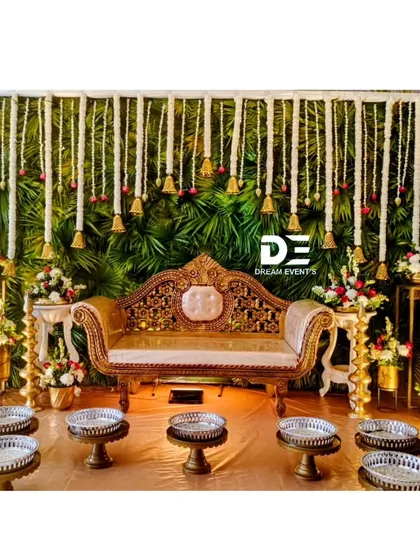 We bring the authentic spirit of a South Indian baby shower to life with this traditional setup. The backdrop features a lush wall of green leaves and hanging tuberose garlands, complemented by a royal chaise lounge and traditional seeru trays for the ceremony.