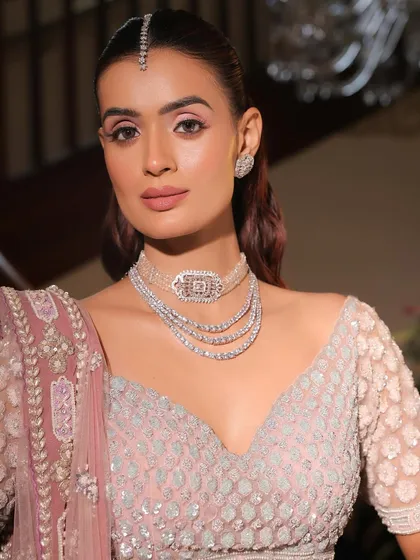 A close-up on the monochrome pink makeup. The soft pink on the eyes, cheeks, and lips creates a harmonious and romantic look, enhanced by the sparkle of diamond jewellery.