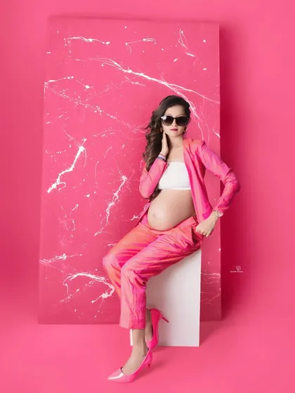 Who says maternity can't be high fashion? This mom-to-be is rocking a bold pink pantsuit, showing that you can embrace your personal style, whether it's glam, chic, or modern, during your pregnancy photoshoot.