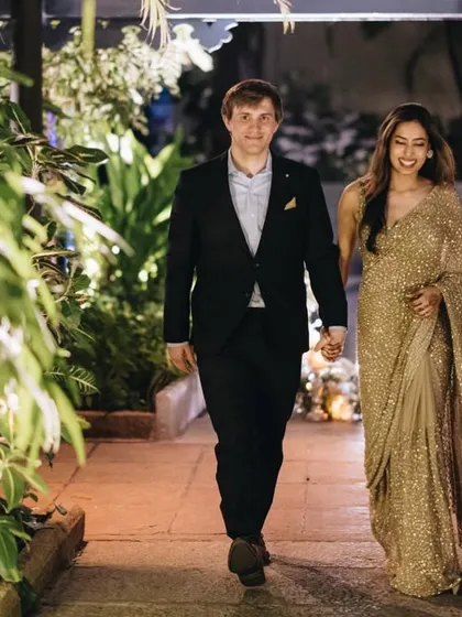 An entrance to remember. We ensure our couples look coordinated without being overly matched. Here, the groom's classic suit and the bride's golden saree create an effortlessly elegant statement.