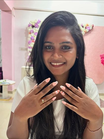 Another happy shot of Ashwini Ambrish with her pretty pink and white floral nails.