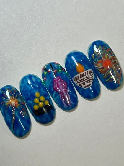 Beautiful Diwali-themed nail art by a student. This set features classic festive symbols like diyas, lanterns, and fireworks, showing great character work.
