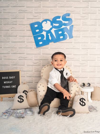 A classic boss baby pose in his mini armchair. The letter board announces his big milestone: "Boss Baby Mishay Turns One".