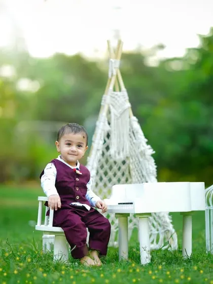 Celebrating a first birthday outdoors with a mini piano and a teepee, creating a whimsical and natural setting.