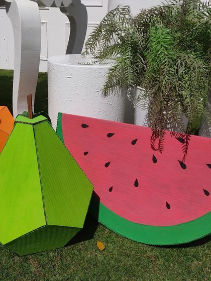 These giant, 3D fruits were part of 'The Hungry Caterpillar' theme. I crafted a watermelon slice, a pear, and an orange from cardboard to serve as fun, vibrant props scattered around the party area.