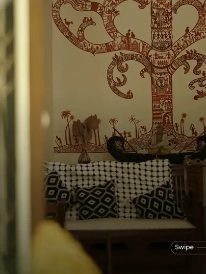 A beautiful Warli art mural of a tree of life adorns the wall, adding a significant cultural and artistic statement to the room.