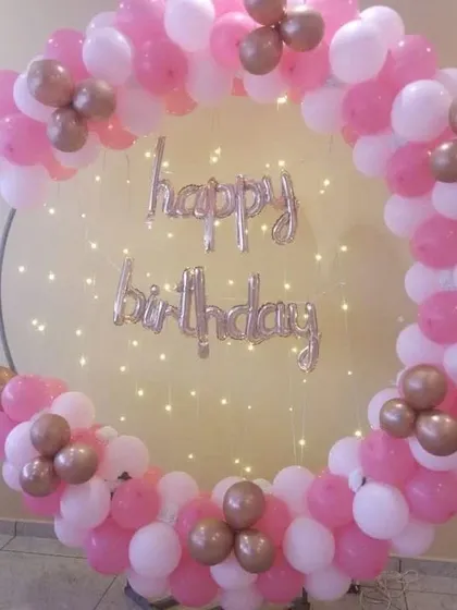 A simple pink and white balloon ring with fairy lights, ideal for a girl's birthday party.