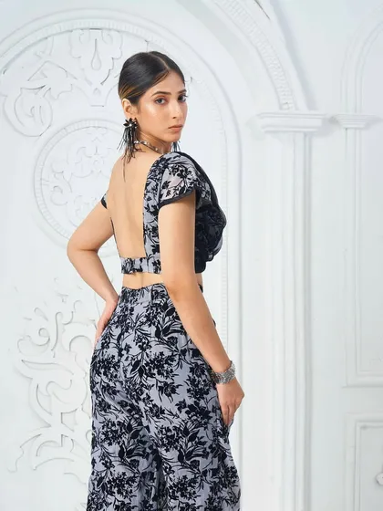 A backless designer outfit requires a complete look. The makeup is chic and modern, with a sleek hairstyle to complement the outfit's design.