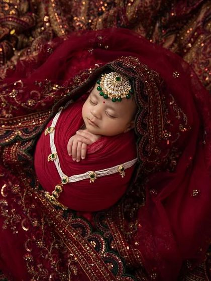 Another beautiful angle of the desi heritage theme, capturing the baby's peaceful sleep amidst the splendor of her family's traditions.