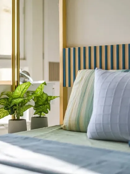 Another view of the guest bedroom, showing the layers of texture in the bedding and the beautiful natural light from the window.