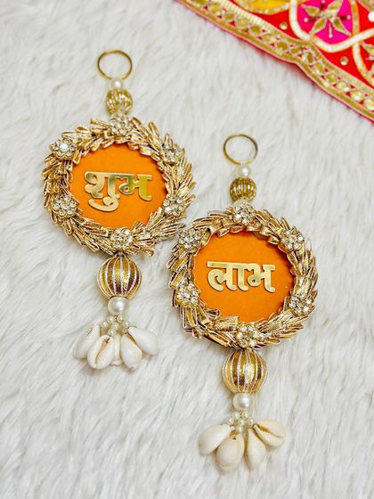 An elegant Shubh Labh set with a golden wreath design and shell tassels. This piece combines modern aesthetics with traditional blessings, perfect for a contemporary home.