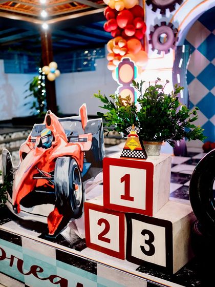 A winner's podium with a number '1' block and a race car cutout, a perfect photo spot for the birthday boy.