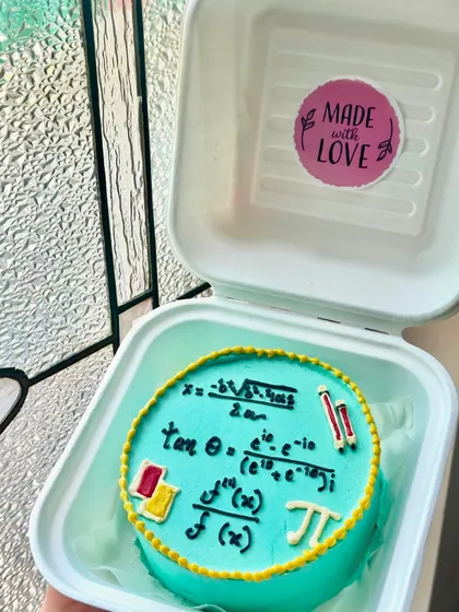 A bento cake for a math lover, complete with intricate formulas and symbols piped in buttercream. We can create a custom design for any hobby or passion.