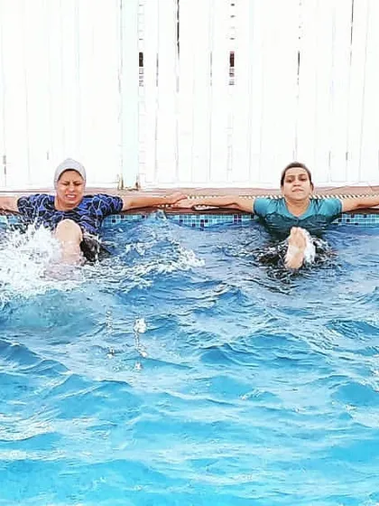 Here, the class is performing flutter kicks while holding the side of the pool. This is an excellent low-impact exercise for strengthening the core and leg muscles.
