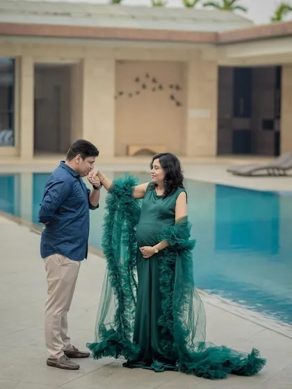 A romantic poolside moment. The location adds a touch of luxury and serenity to this couple's maternity portrait.