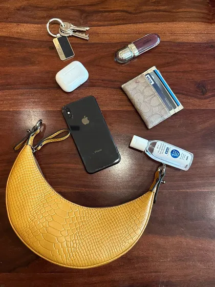 A 'what's in my bag' shot featuring the Selena Tan Croc. It’s surprisingly spacious, comfortably fitting my phone, wallet, keys, and other daily essentials.