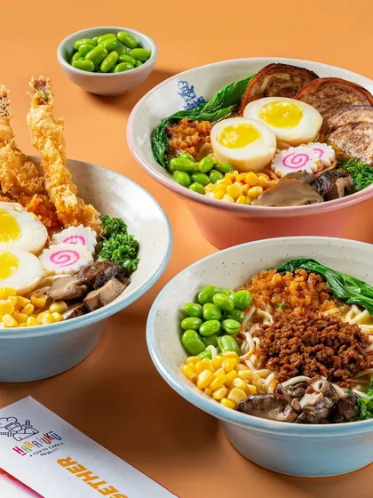 A trio of colorful ramen bowls from Harajuku Tokyo Cafe, showcasing different toppings like tempura shrimp and chashu pork.