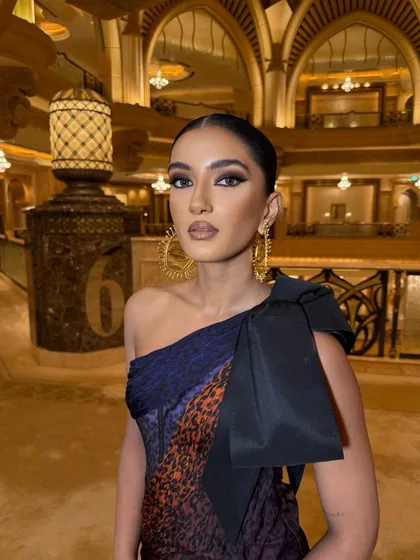 A high-fashion moment in a Schiaparelli gown. The makeup is sculpted and defined, with a strong focus on the eyes to match the avant-garde outfit.