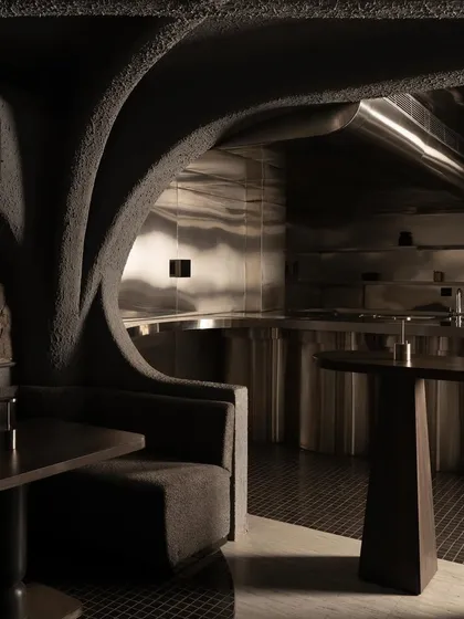 A closer look at the fusion of materials. The raw concrete shell opens to reveal a sleek, stainless steel kitchen, creating a dynamic contrast between the primal and the precise, the raw and the refined.
