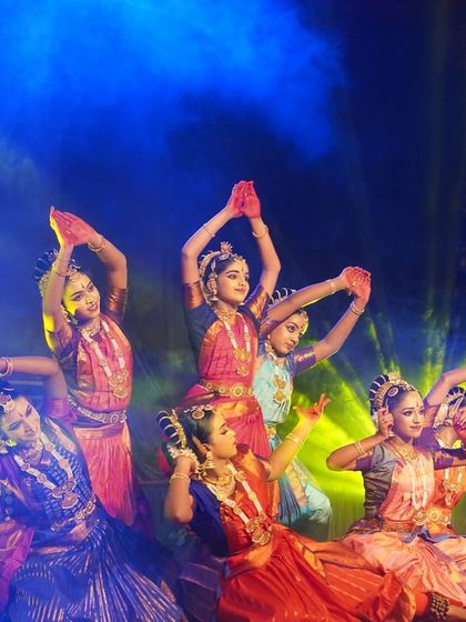 A group of our dancers in a graceful formation during the "KRISHNA" performance at Udupi. The rich colors of their costumes stand out against the dramatic stage lighting.