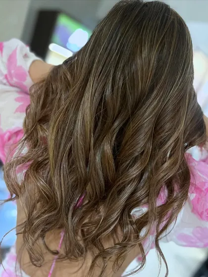 This caramel and beige highlight blend was achieved using a balayage technique with back-to-back foils for a bright and dimensional result.
