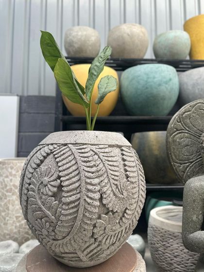 A wider shot of the spherical 'Lembar' planter, showing how it stands out amongst other pots.