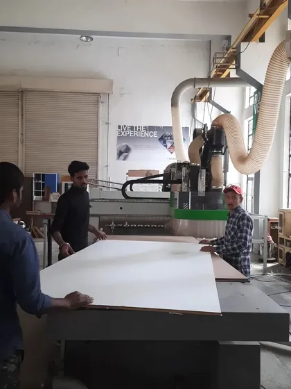 Our students learn to operate advanced CNC machinery, a critical skill in modern woodworking. Here, they are preparing a large panel for automated cutting, bridging traditional craft with digital fabrication.