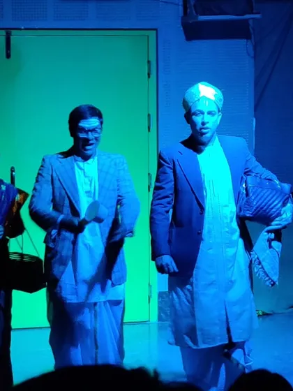 A scene from the student production of "The Good Doctor," with actors in costume and character under blue stage lighting.