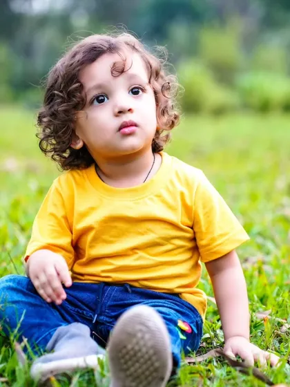 A thoughtful moment in the grass. Outdoor sessions allow for beautiful, natural portraits with soft lighting and a relaxed atmosphere.