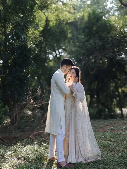 A serene portrait of a couple standing together in the lush, sun-dappled woods of Hauz Khas, Delhi.