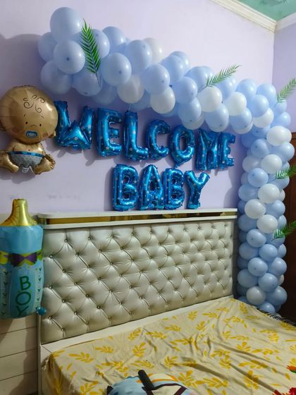 This is a popular design for welcoming a baby boy. I create a balloon arch in shades of blue over the bed, complemented by 'Welcome Baby' foil letters and cute baby-themed foil balloons.