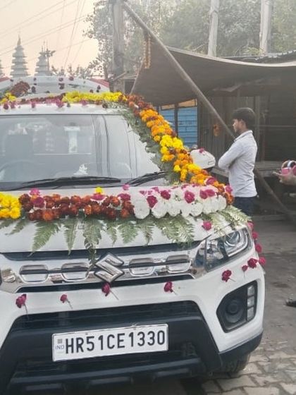 A Maruti Suzuki Brezza decorated with traditional marigold and rose garlands, seen here just after the decoration was completed.