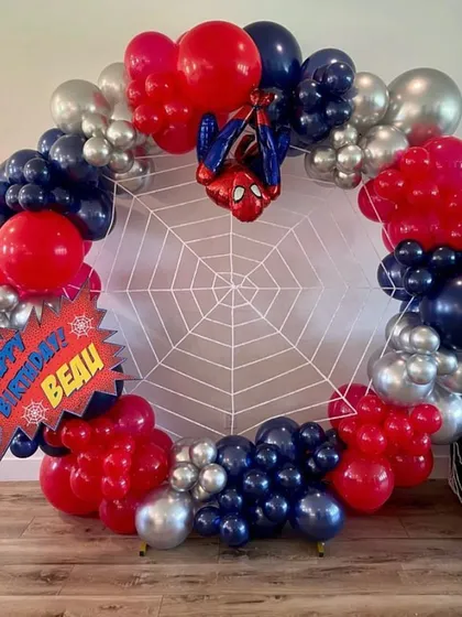For the little superhero, a Spiderman-themed party is always a hit. This setup includes a full balloon ring in red, blue, and silver, complete with a spiderweb backdrop and a Spiderman foil balloon right in the center.
