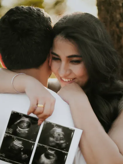 Sharing the secret. This close-up shot of the couple with their sonogram pictures is an intimate and emotional way to announce a pregnancy.