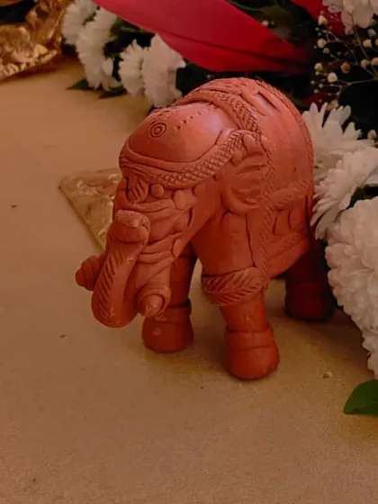 A small terracotta elephant figurine used as part of the table decor. These little details add character and a touch of Indian tradition to the overall design.